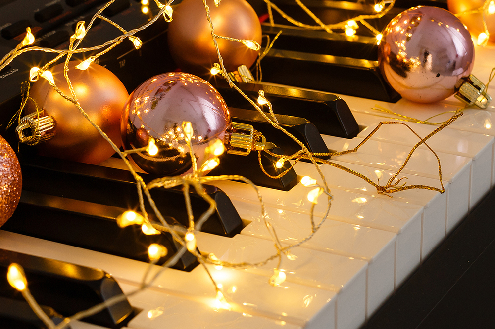 A piano with christmas lights and tree